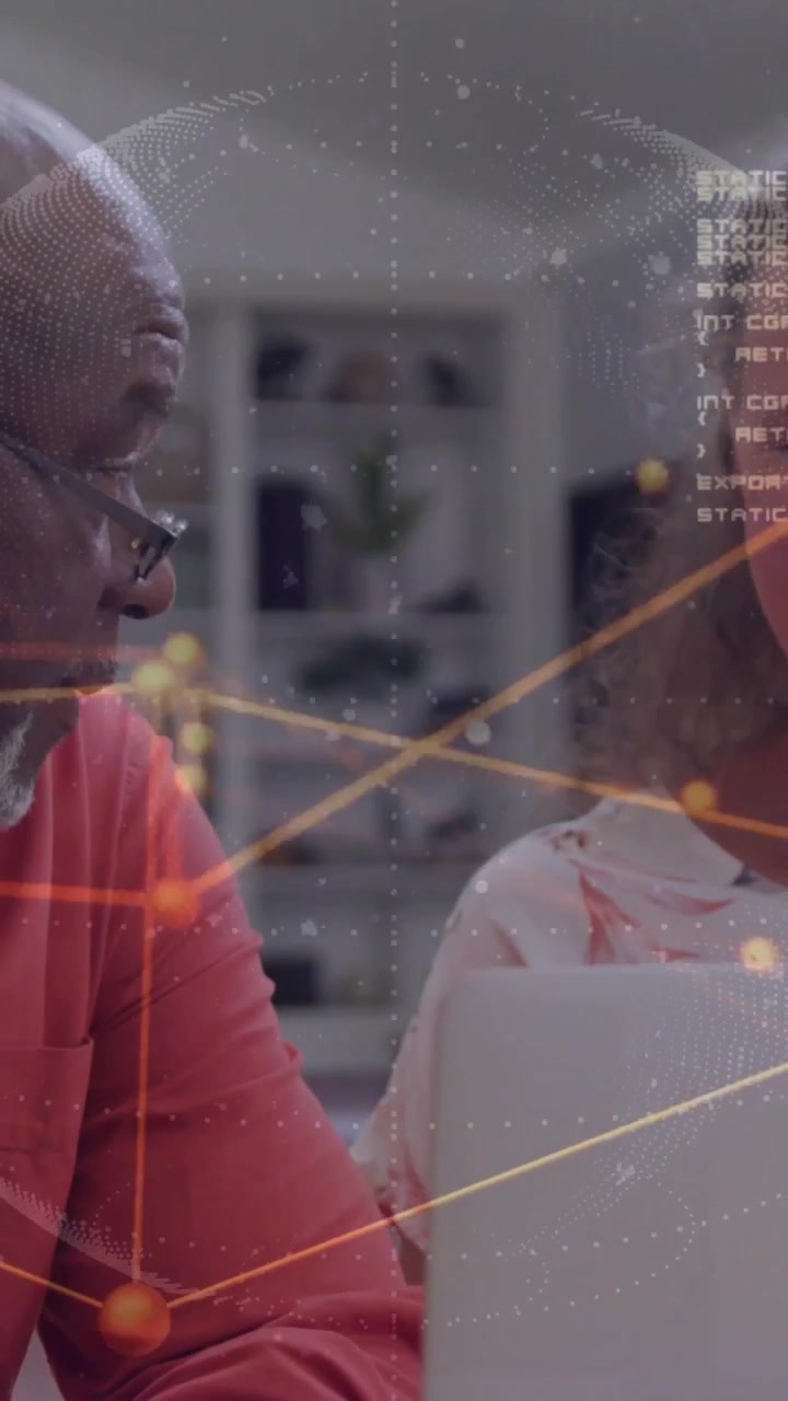Vertical video: Senior leaning, speaking, woman reviewing laptop, globe overlay showing IT data