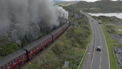 Toma-Aérea-De-Seguimiento-Del-Mallaig-Jacobite-Express-Del-Tren-Que-Sale-De-La-Estación