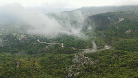 aerial overview of rolling mist over zagori mountains, creating a mystical scene in greece above winding roads of papigo