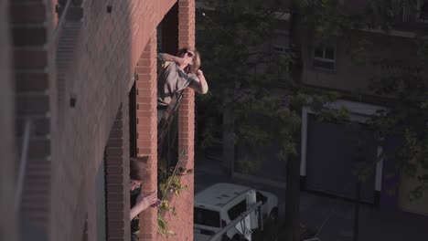 older woman on balcony in city