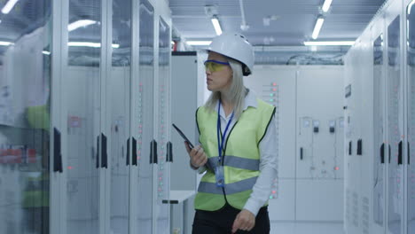 female technician inspecting server room equipment