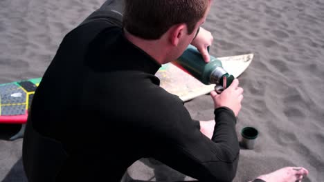 young man serving a drink of mate, argentine drink, surfer, pichilemu, punta de lobos, chile