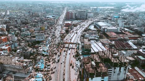 Toma-Aérea-De-Una-Carretera-Muy-Transitada-Por-Donde-Pasan-Vehículos-En-Dhaka,-Bangladesh