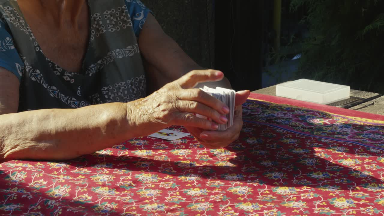 Grandma shuffles playing cards for family summer holiday fun activity