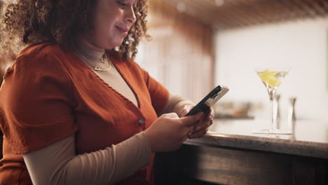 mujer usando el teléfono en un bar