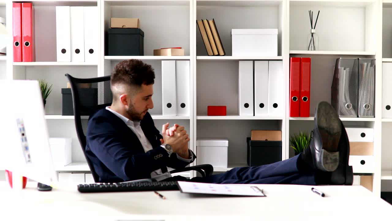 giovane uomo d'affari che alza le mani in un ufficio moderno