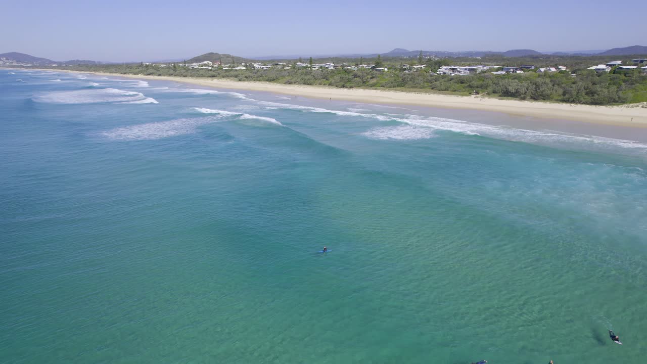 playa soleada con surfistas durante el verano en queensland, australia - foto aérea