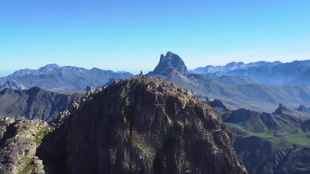vista aérea del pico de la cordillera de anayet con gente de pie en la cima y vistas del pico midi d ossau en los pirineos español y francés en la mañana de verano
