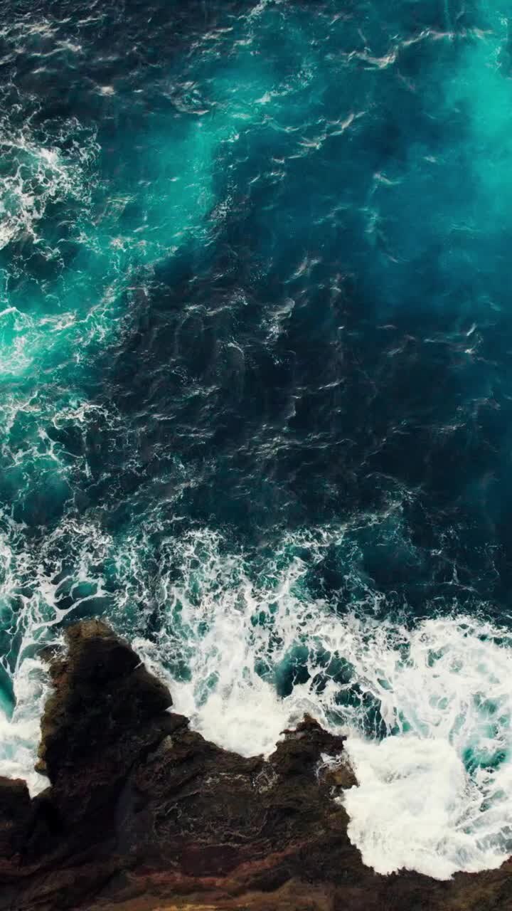 Le onde dell'oceano si scontrano con le rocce