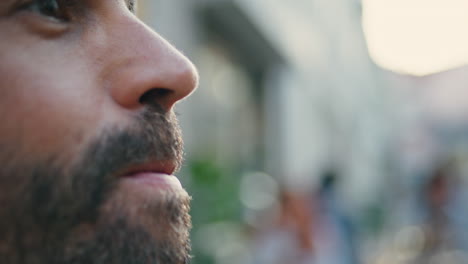hombre barbudo bebiendo un vaso de vino en una calle de la ciudad. hombre cara bebiendo alcohol