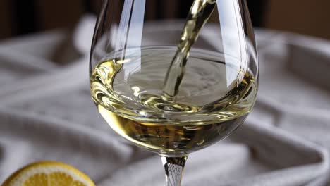 pouring white wine into a glass on a table, accompanied by a vibrant lemon slice, creates a refreshing and inviting atmosphere perfect for celebrations or gatherings