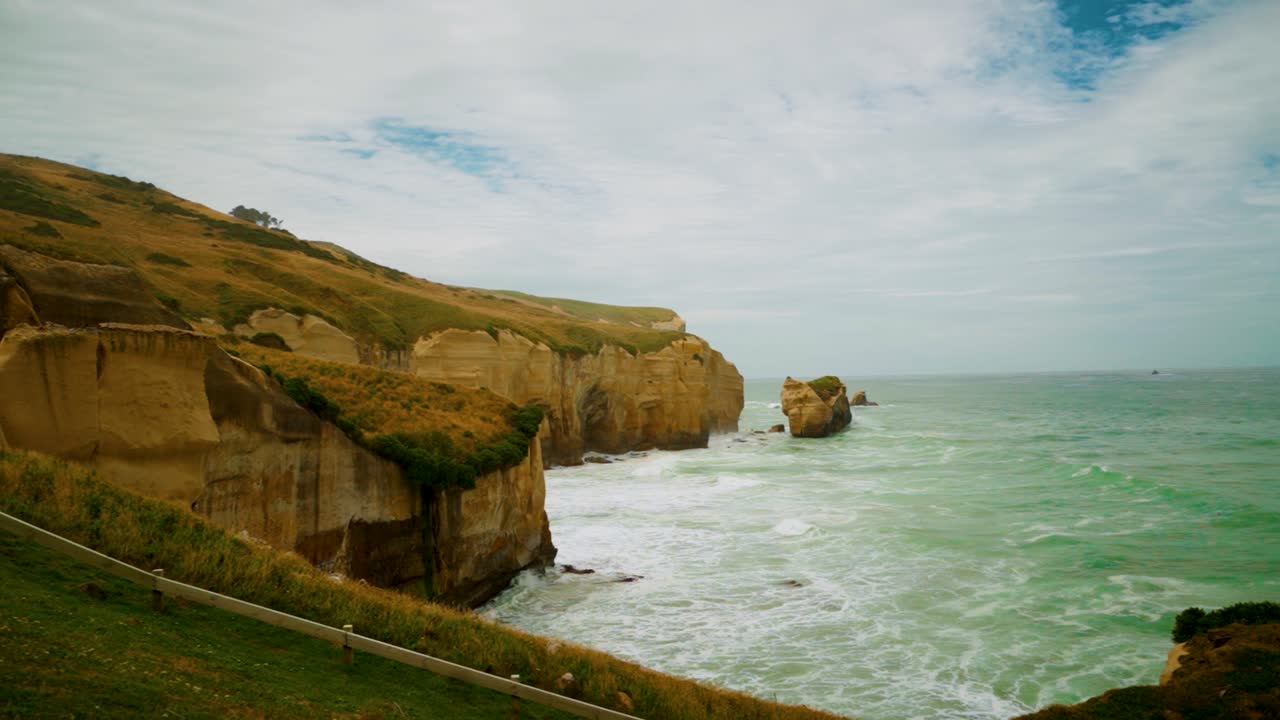 acantilados a lo largo de la costa en nueva zelanda con olas golpeando la pared del acantilado