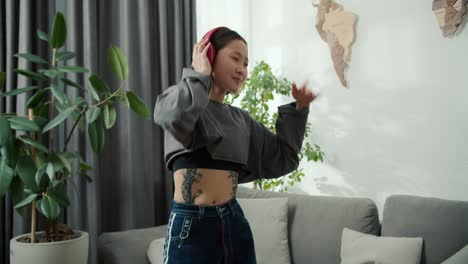 Asian-beautiful-girl-with-tattoos-enjoy-listen-to-music-and-dance-at-home