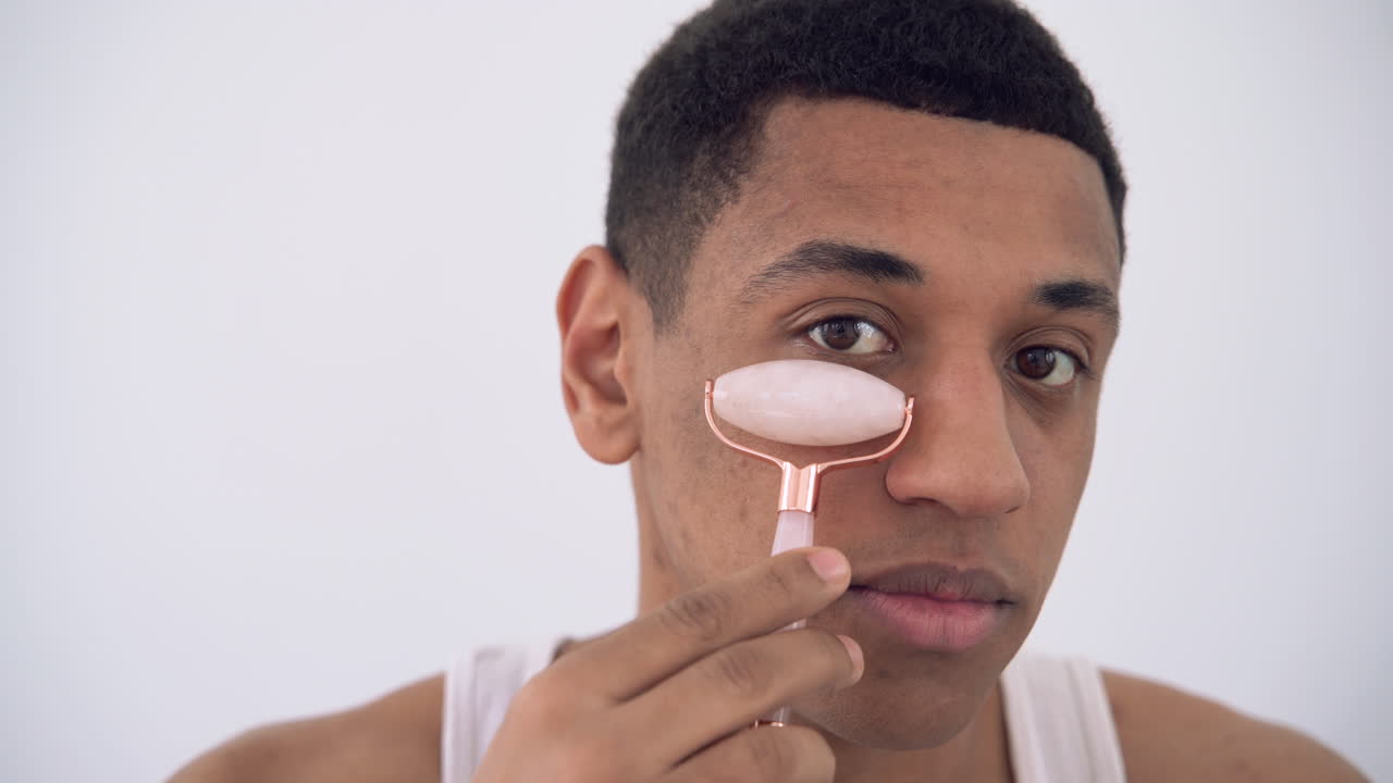 얼굴 마사지 기계 롤러 조각 도구를 사용하는 흑인 남성의 초상화 1