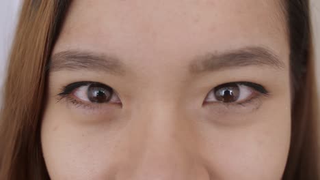 close up of middle eastern young woman face, the girl has beautiful brown eyes, she smiles, frowns, draws her eyebrows