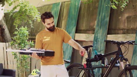 Man-examining-bicycle-toolbox-in-yard