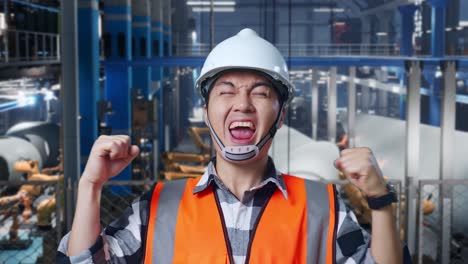 happy engineer celebrating success in a factory