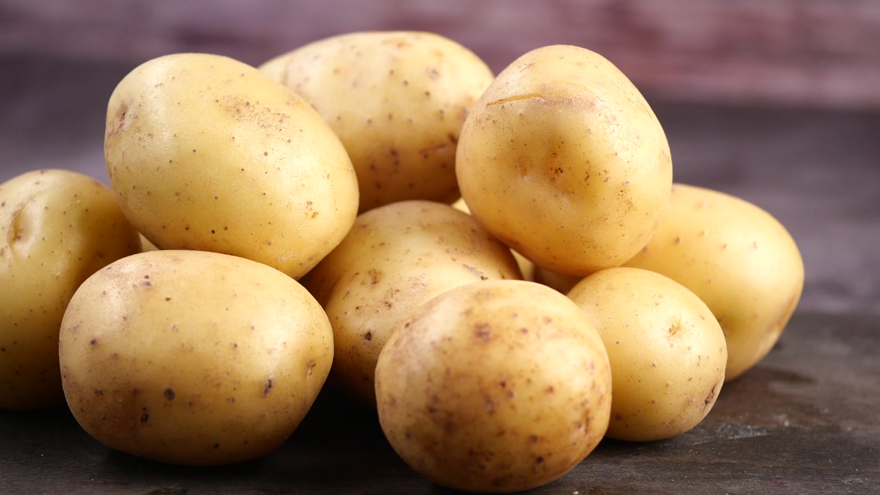 Fresh Raw Potatoes on Dark Background