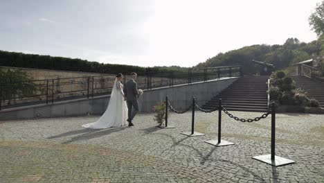 Schöne-Frischvermählte-Kaukasische-Braut-Und-Bräutigam-Spazieren-Im-Park,-Halten-Händchen,-Hochzeitspaar-Familie