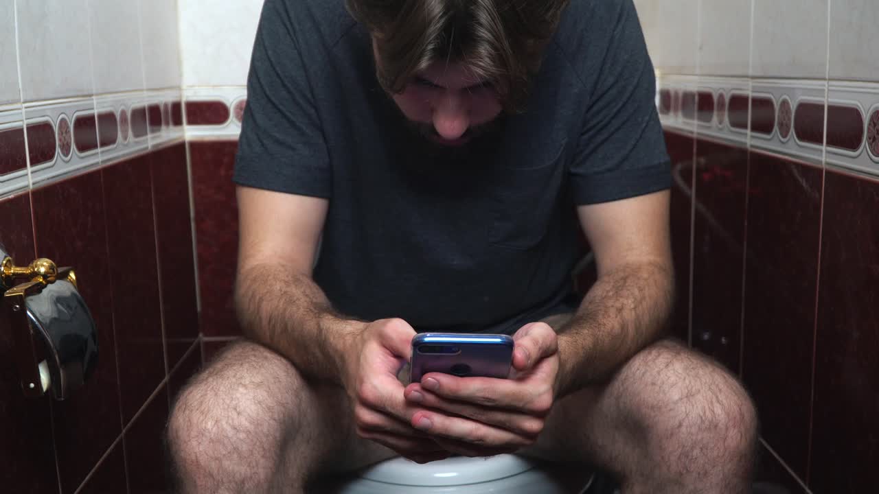 hombre usando el teléfono en un baño