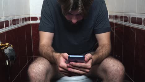 man using phone in a bathroom