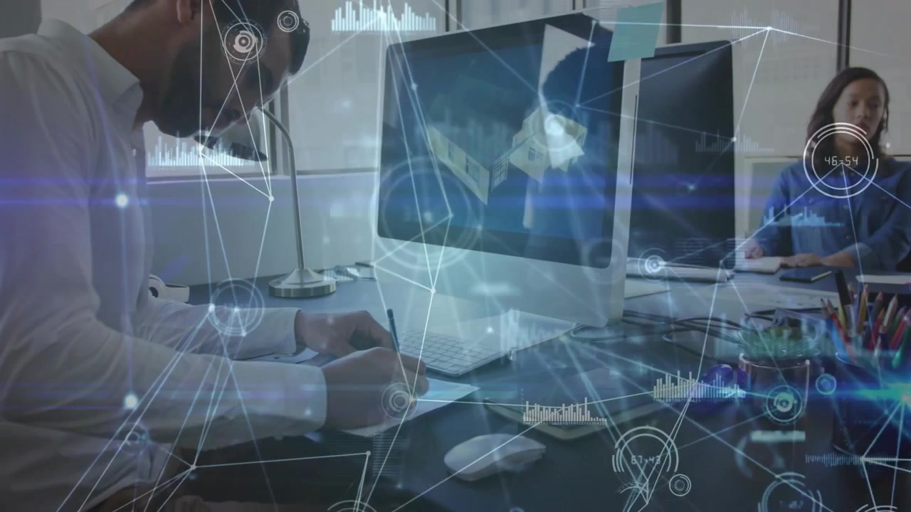 Seated man noting monitor for technology planning, HUD animating around desk as camera pulling back