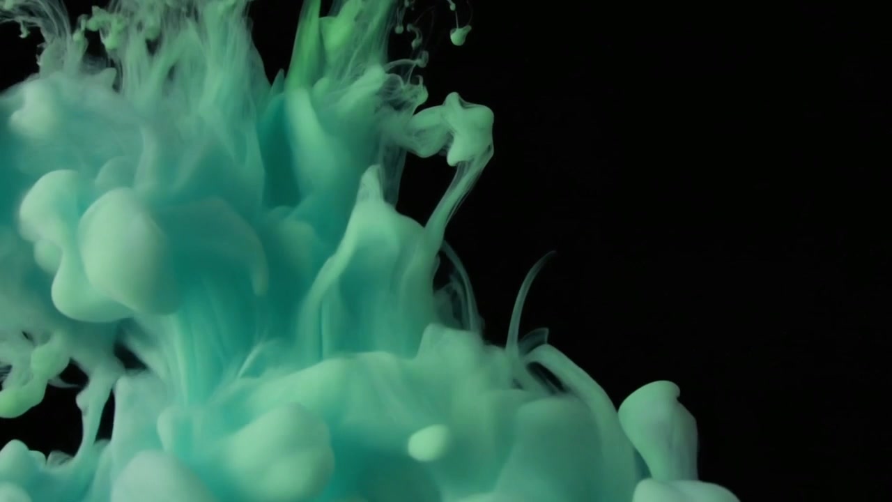 Turquoise Ink Dropping into Water Creating Abstract Swirls