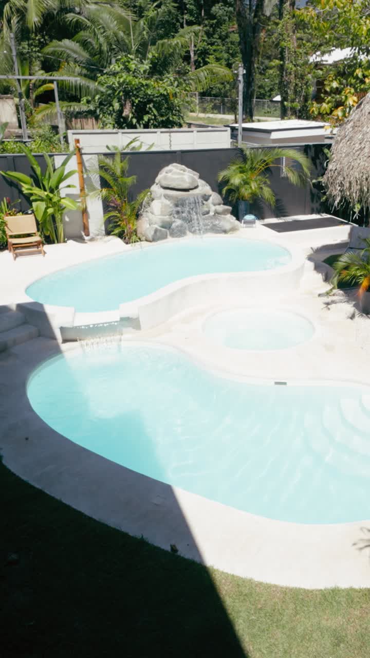 Luksuriøs swimmingpool i flere niveauer i en tropisk have.
