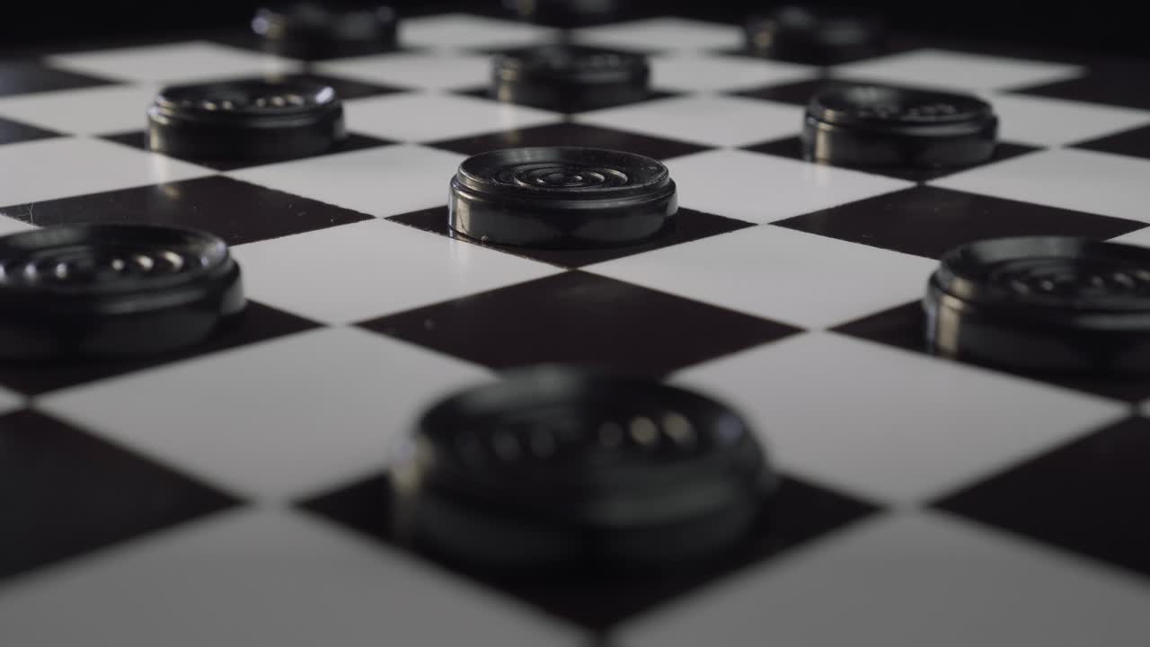 Checkers board with black pieces lit up by shafts of light (Draughts)