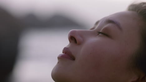 close up portrait beautiful asian woman looking up praying contemplating journey enjoying calm seaside at sunset exploring spirituality feeling inspired