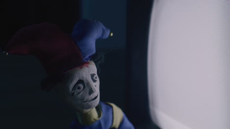 jester puppet in front of a tv