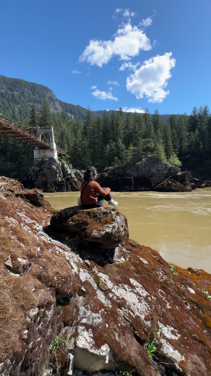 Kvinde betragter den gamle Alexandra Bridge ved Fraser River i British Columbia, Canada