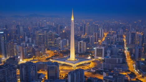 aerial night view of a modern city with an illuminated landmark tower