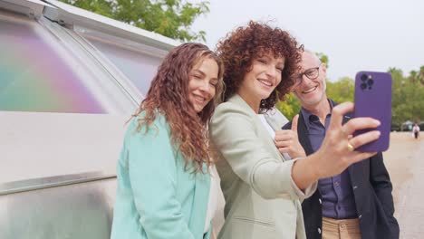 Three people looking at a phone in an urban setting