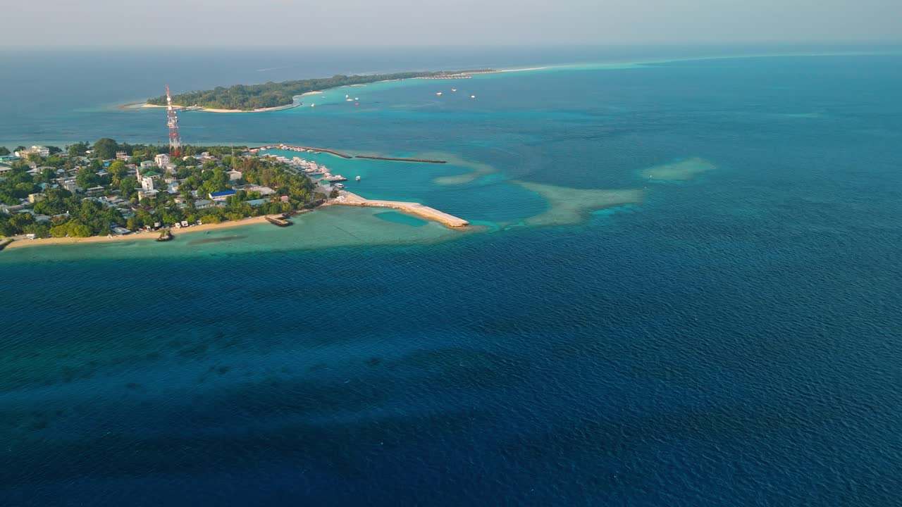 A breathtaking aerial drone view captures Rasdhoo Island bathed in the warm glow of sunset in the Maldives.