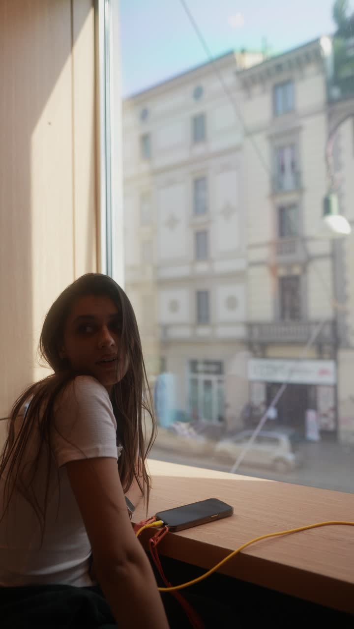 Woman looking out window at city view in cafe