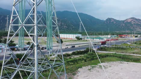 imágenes aéreas de drones de torres eléctricas de alta tensión con aislantes de vidrio prefabricados para distribuir electricidad en un parque industrial - concepto de desarrollo y urbanización