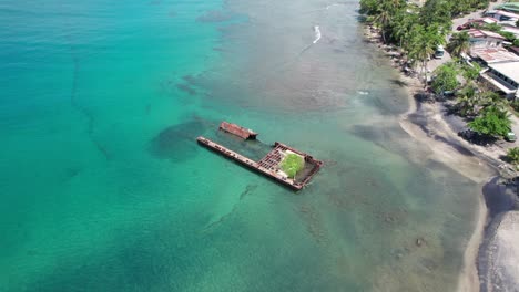 aerial zoom-in towards puerto viejo beach coastline, highlighting the contrast between sea and sand.