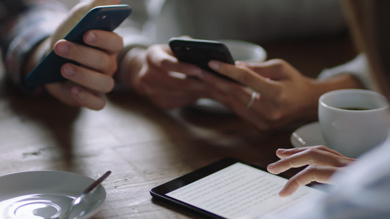 business people hands using smartphone browsing working online collaborating on mobile technology networking together friends relaxing in cafe drinking coffee enjoying leisure lifestyle close up