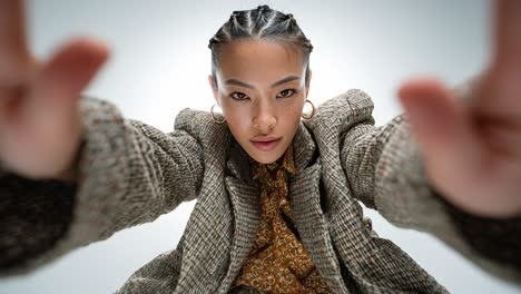 fashion model posing and touching face in slow motion on white background
