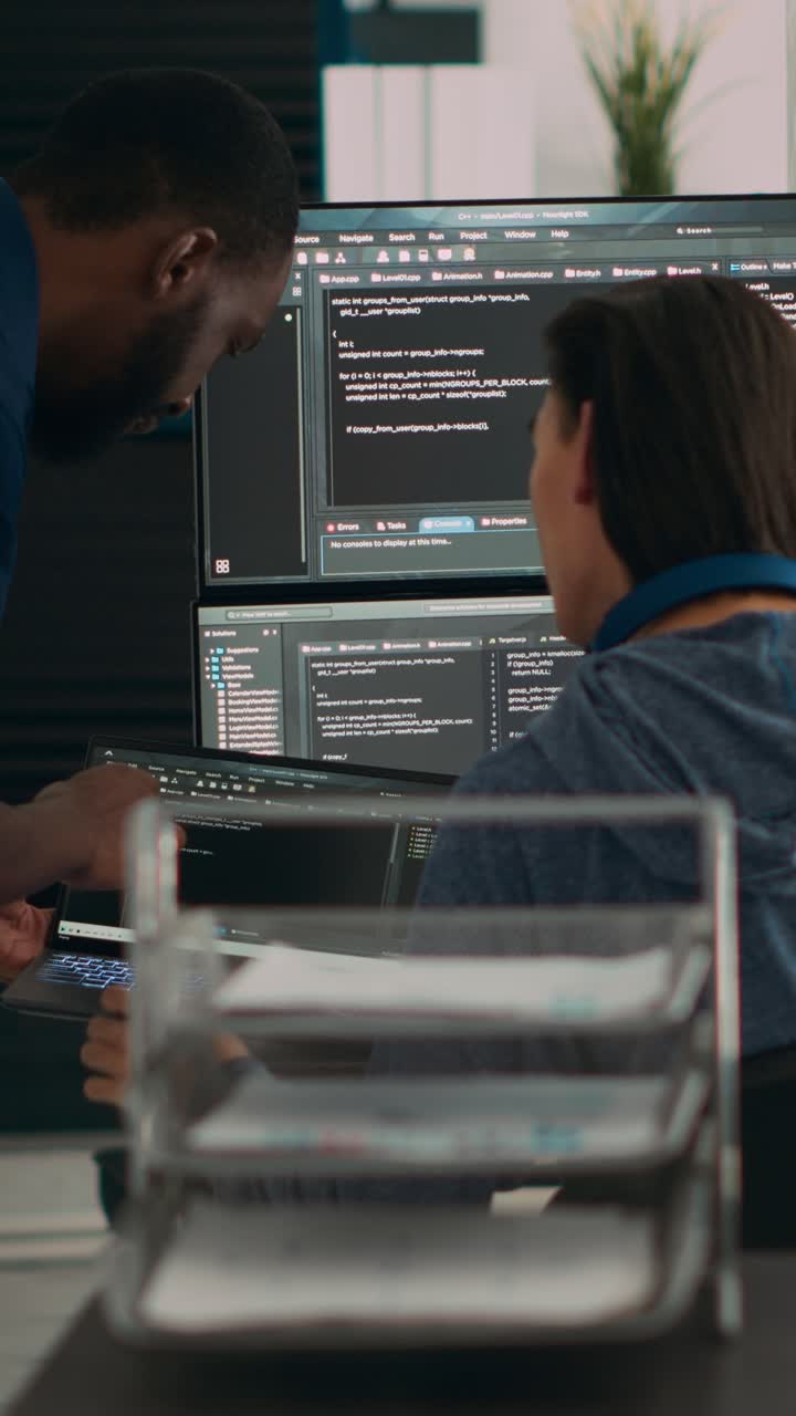 Vertical video: Diverse team of data programers analyzing code programming on laptop