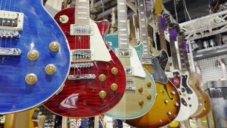 many electronic bass guitars hang on the wall in the shop.