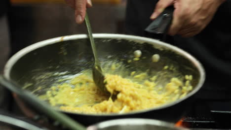 chef cocinando una salsa cremosa en una sartén y mezclándola con una cuchara