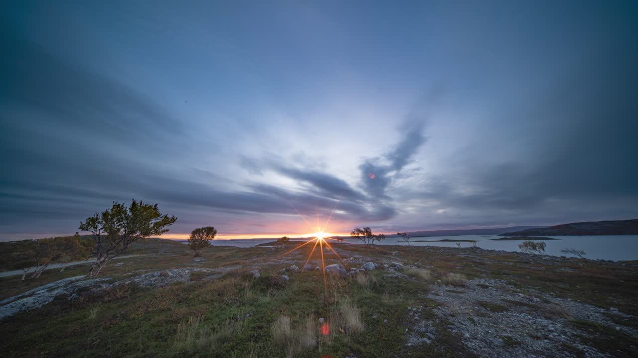 un sol se levanta en el cielo de la mañana sobre el fiordo tranquilo y la tundra de otoño
