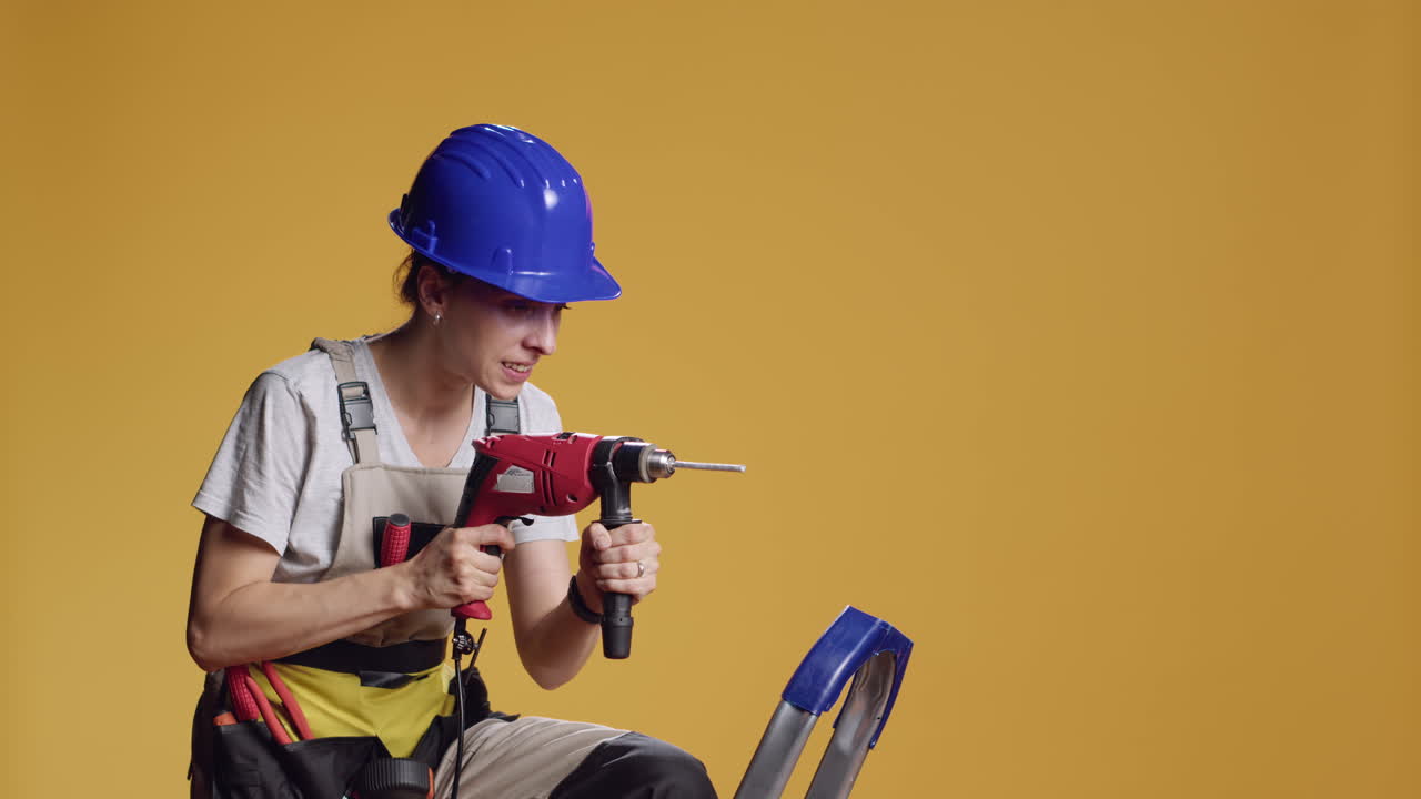 Strong handywoman drilling nails with power drill gun