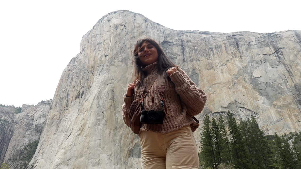 Mulher Feliz com Mochila Olhando para Montanha Majestosa