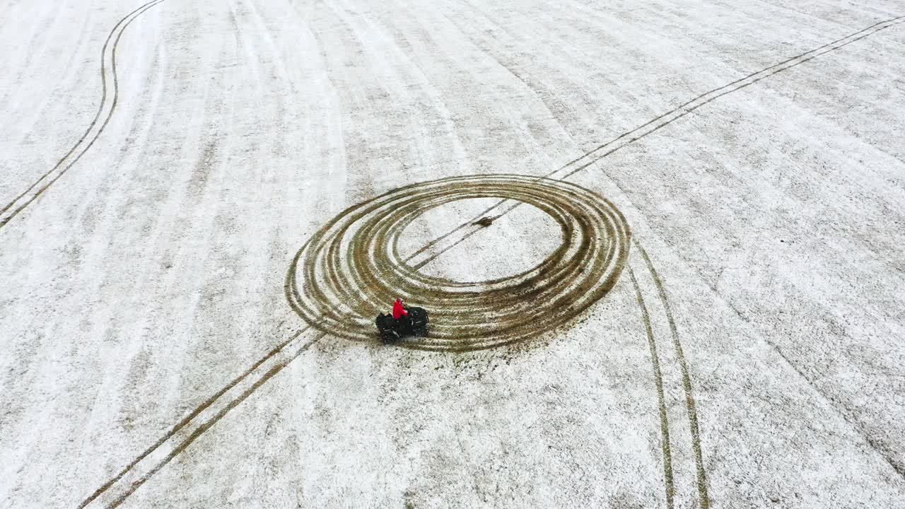 la persona adulta en un atv en un campo agrícola lleno de nieve - vista aérea