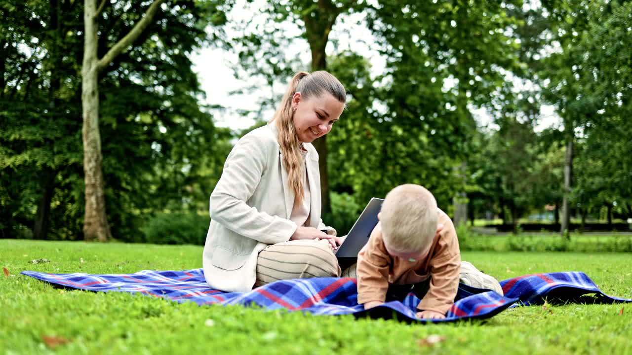 Mor sidder på græsset i parken, og hendes lille søn løber rundt. En kvinde arbejder fjernstyret på barselsorlov. En freelancemor arbejder online udendørs, mens hun går tur i parken.