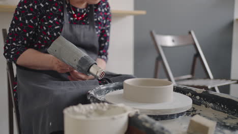 Dry-a-ceramic-blank-for-dishes-with-a-hair-dryer.-Pottery-workshop