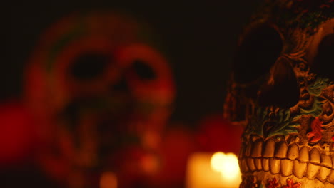 close up on still life of decorated skulls lit by candles celebrating mexican holiday of dia de muertos or day of the dead 9